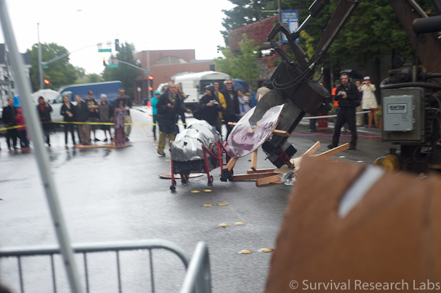 Big Arm rips the Stick Wheel Robot apart as BugBot scurries past in heels