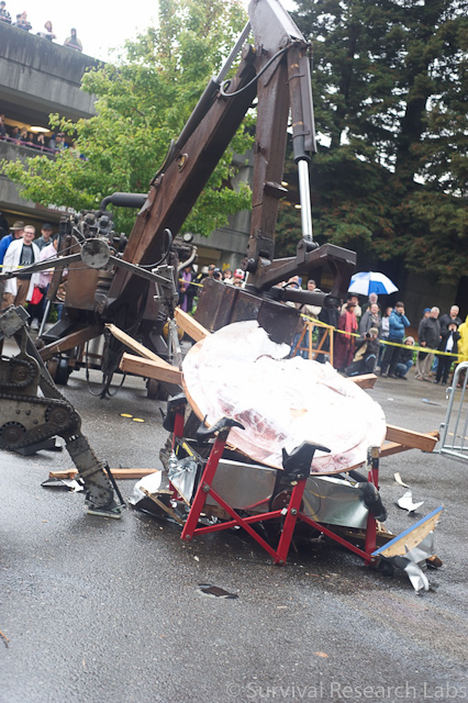 Big Arm drops the Stick Wheel Robot wheel on the capsized BugBot